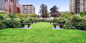 Multiple estate areas with buildings in the background at Pierce Bros. Westwood Memorial Park. 