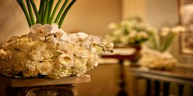 Floral arrangement in a vase on top of a table inside a funeral home. 