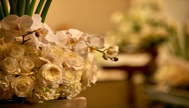Floral arrangement in a vase on top of a table inside a funeral home. 