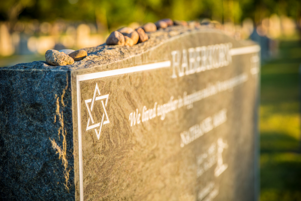 Stones lying on an upright monument engraved with the Star of David.