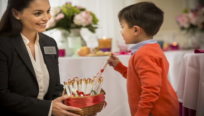Dignity Memorial associate giving a young boy a pencil memento.