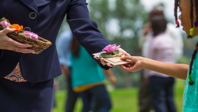 A girl receives a flower and seed packet as a memento of a Life Well Celebrated. 
