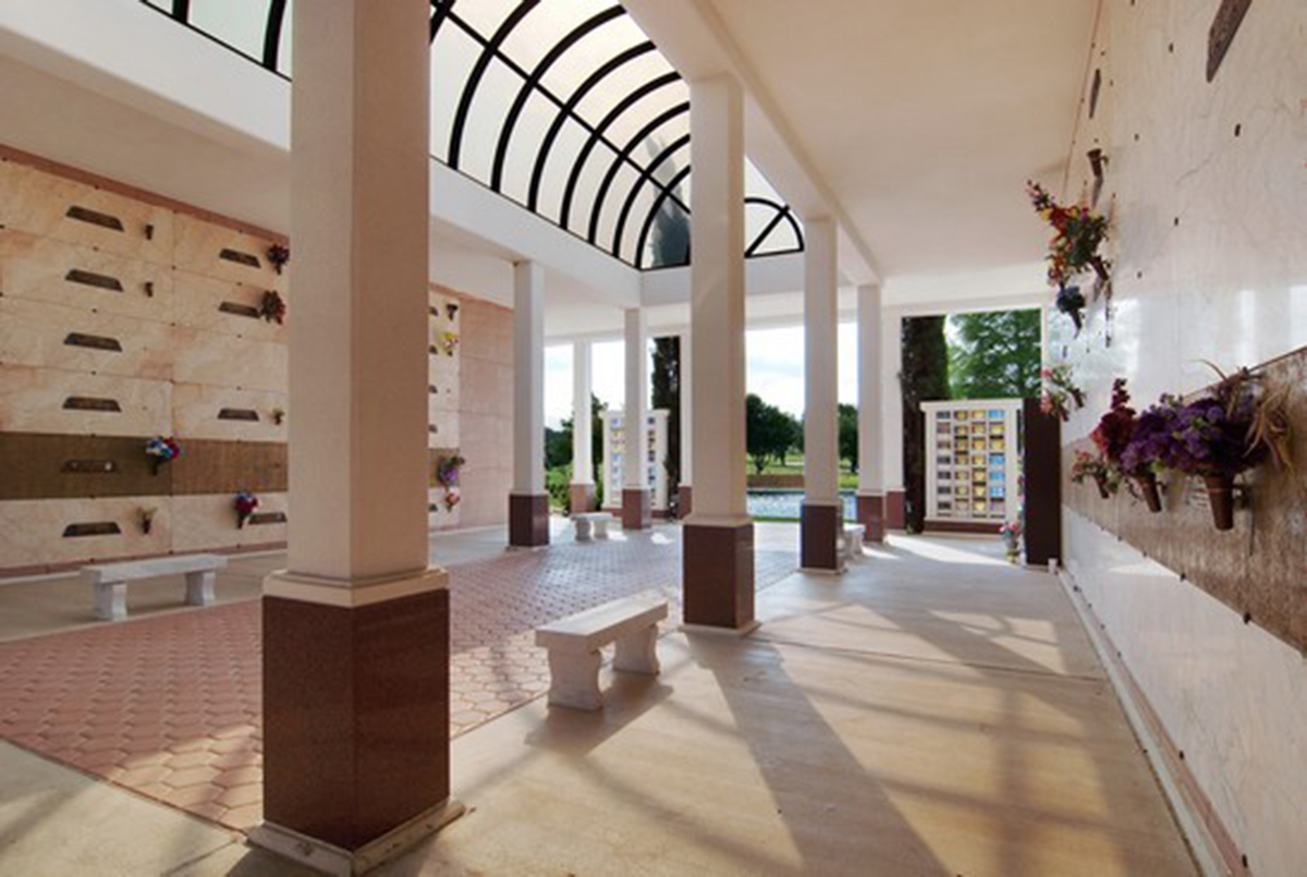 A spacious community mausoleum with a glass ceiling provides benches for guests to rest and reflect at Bluebonnet Hills Memorial Park.