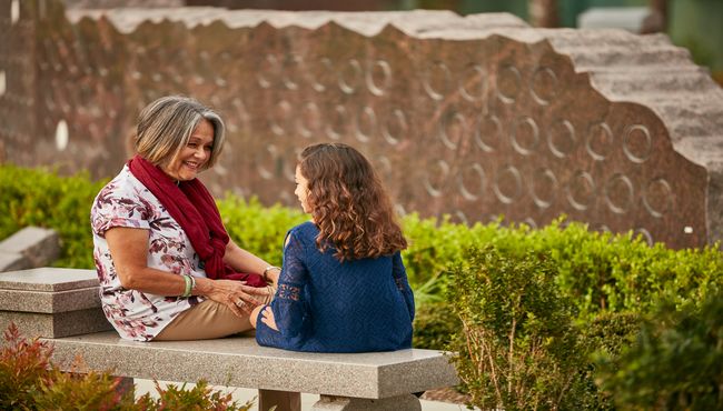 Grandmother and granddaughter sitting on a bench at Pacific View