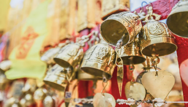 Golden prayer bells hang in a row.  translation needed 