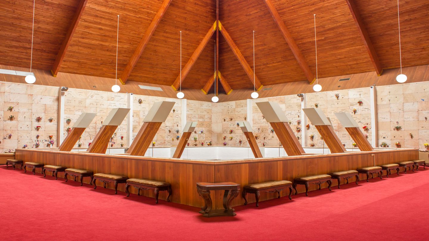 Upstairs of a mausoleum with benches at wooden ceiling at Forest Lawn Memorial Gardens.
