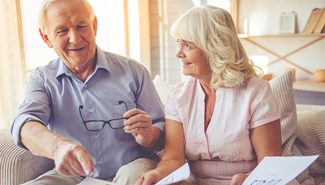 Older man and woman looking at papers and smiling