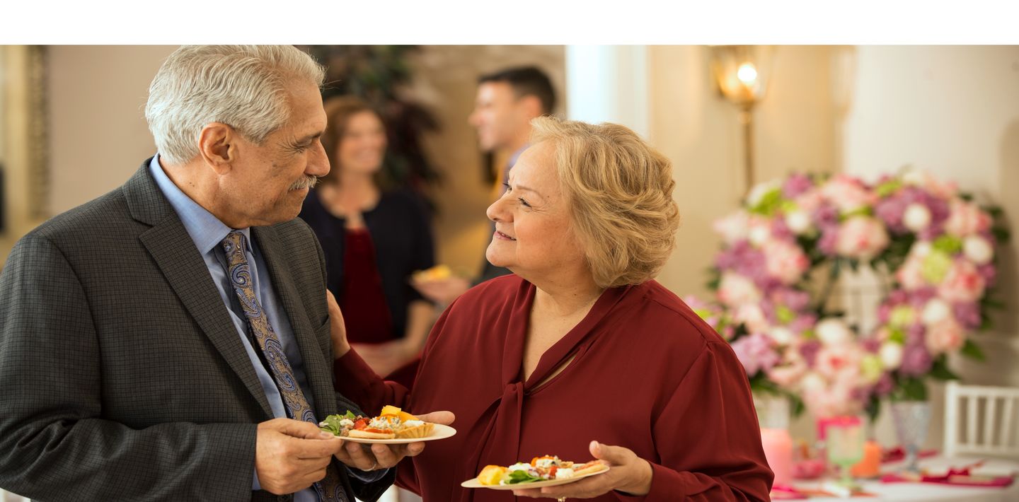 Two guests chat at a decorated catered reception for a teacher
