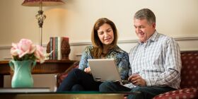 Husband and wife sitting on couch and pre-planning their funerals