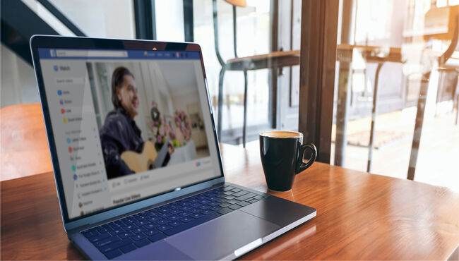 Laptop on wood tabletop with cup of coffee