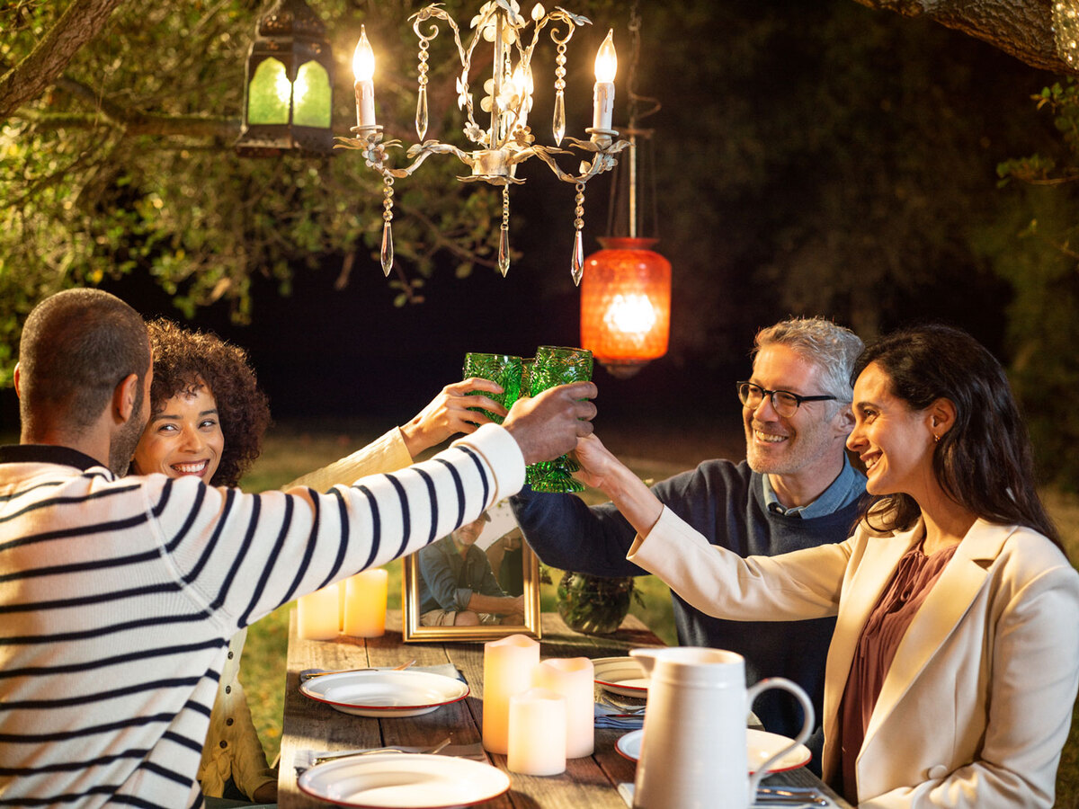 people toasting in celebration of remembrance at a picnic table outdoors at night