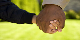 An adult and child holding hands.