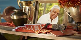 Football coach memorial with urn, trophies, football and pendants