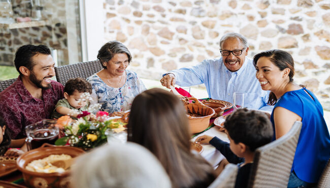 Latin family eating around table