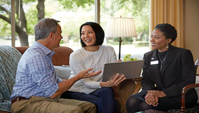 A couple pre-plans on a tablet at a funeral home.