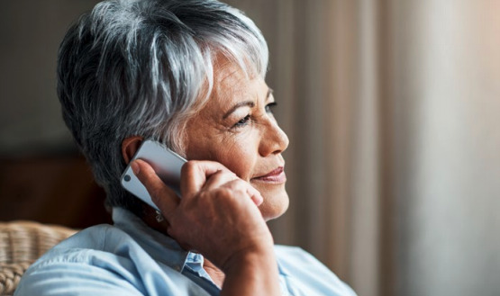 Woman listening to an on-hold message on her mobile phone.