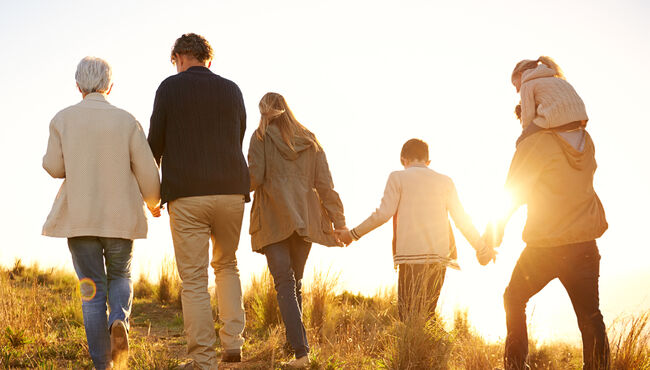 Multi-generational family on a hike looking over a hill