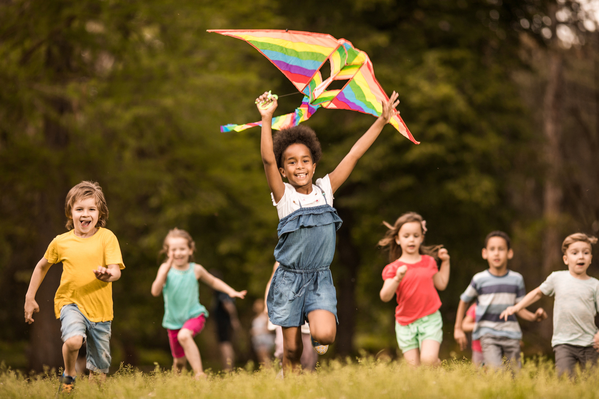 children playing with a kite in a field