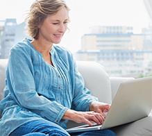 Woman sitting on the couch with laptop.