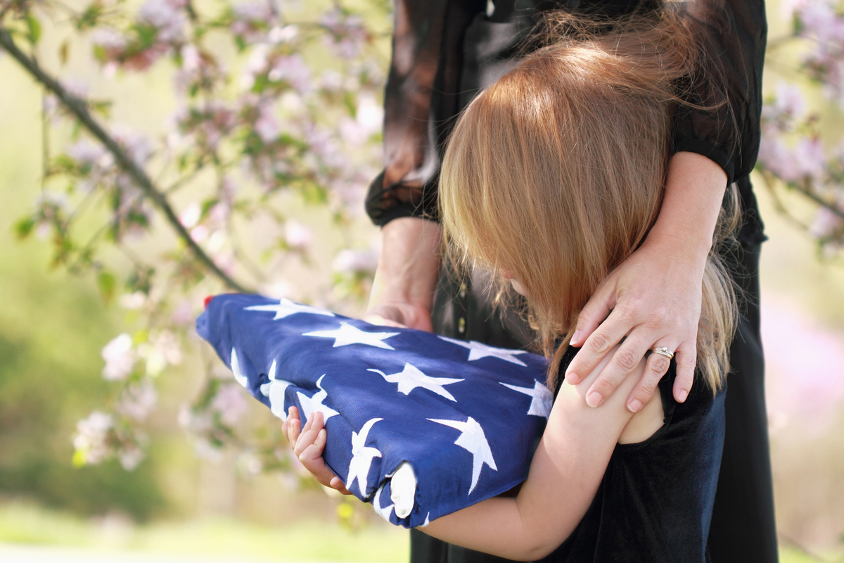 Child Holding a Parent's Folded American Flag
