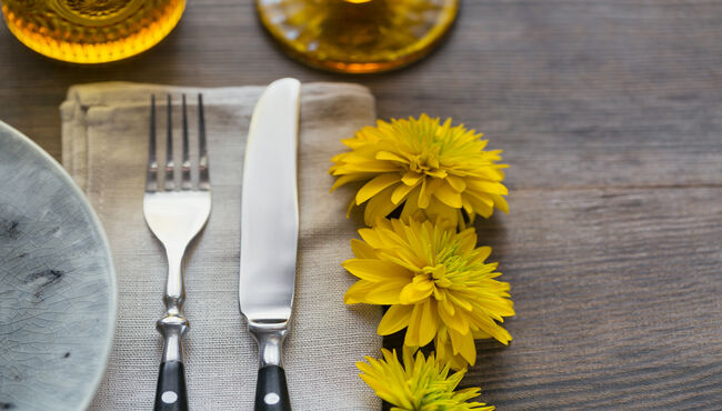 Rustic table setting with linen napkin and yellow flowers