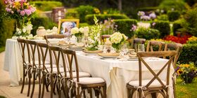 Beautiful outdoor table setting with an urn, portrait and flowers.