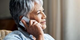 Woman listening to an on-hold message on her mobile phone.