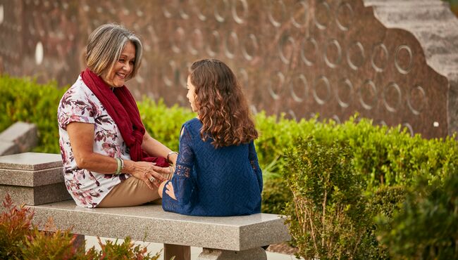Grandmother and granddaughter sitting on a bench at Pacific View