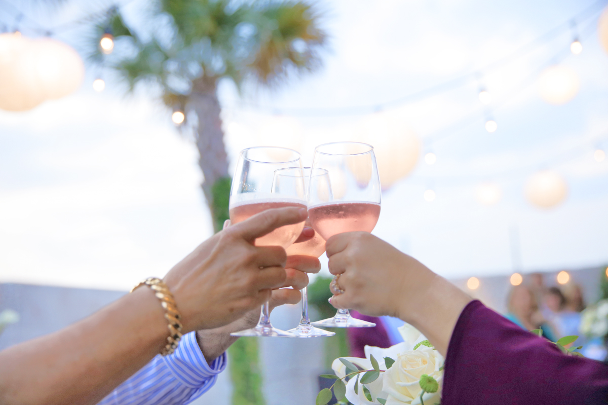 A group of people raise their glasses to toast to a loved one at an outdoor celebration