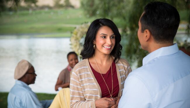 A woman talking to a man while standing at an outdoor service.