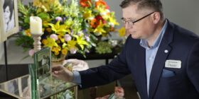 A male Dignity Memorial associate decorates a Memory Table for a celebration of life