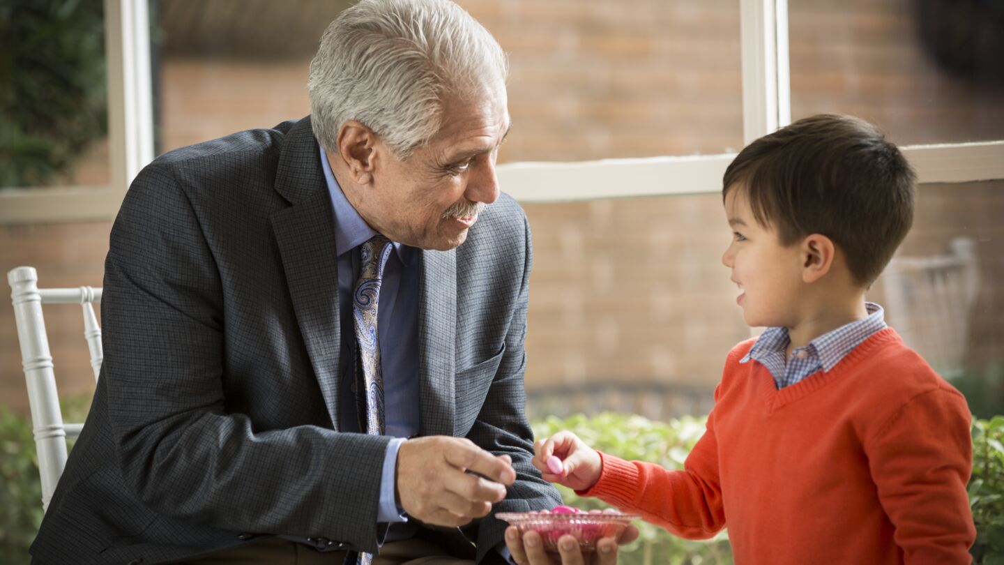 Un grand-père discute avec son petit-fils lors d'une réception.