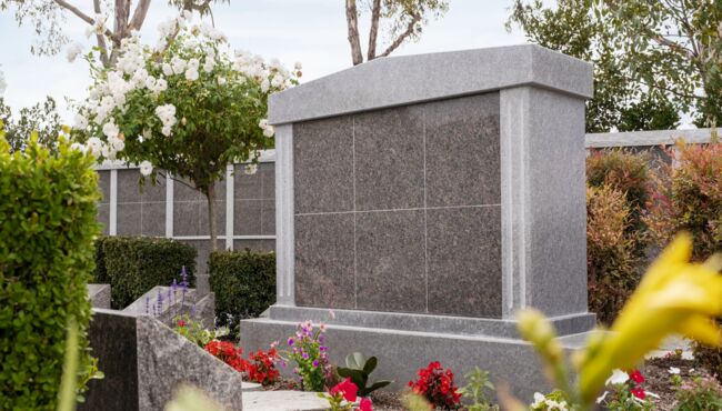 Scenic pathway in the Cremation Garden with flowers, green grass, and trees.