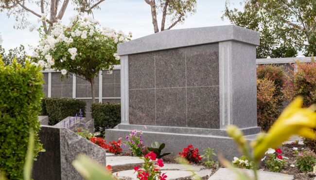 Scenic pathway in the Cremation Garden with flowers, green grass, and trees.