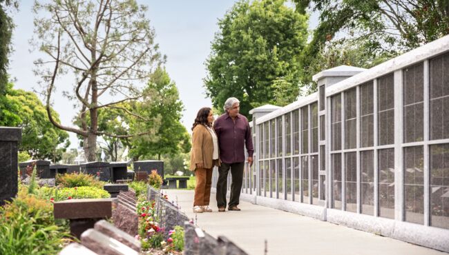A father and daughter visit a loved one’s columbarium in the peaceful cremation garden.