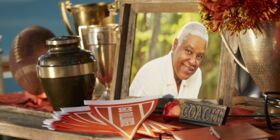 Football coach memorial with urn, trophies, football and pendants