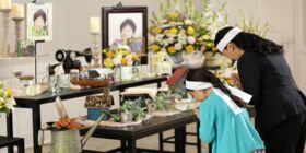 A Vietnamese mother and daughter bow in respect to portraits of their relative who has passed away