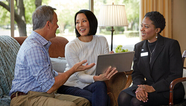 A couple pre-plans on a tablet at a funeral home.